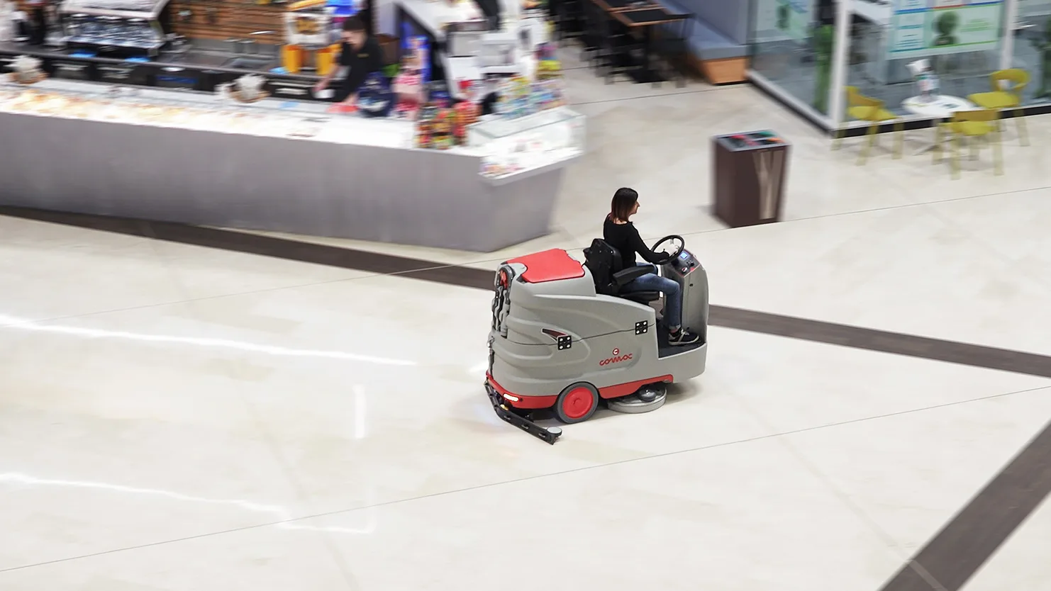 Une autolaveuse autoportée lave le sol d’une galerie marchande