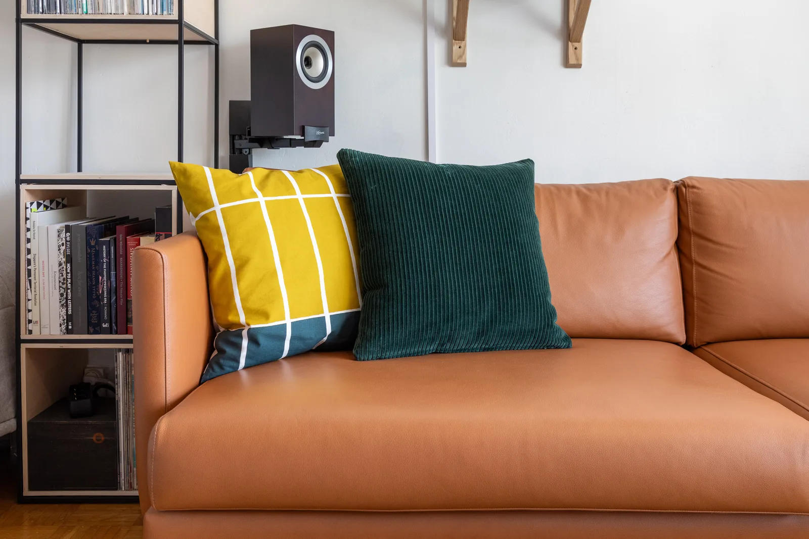 Un canapé en cuir camel et ses coussins, dans un salon