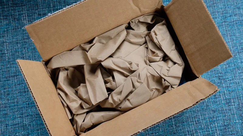 Un carton de livraison ouvert, rempli de papier kraft