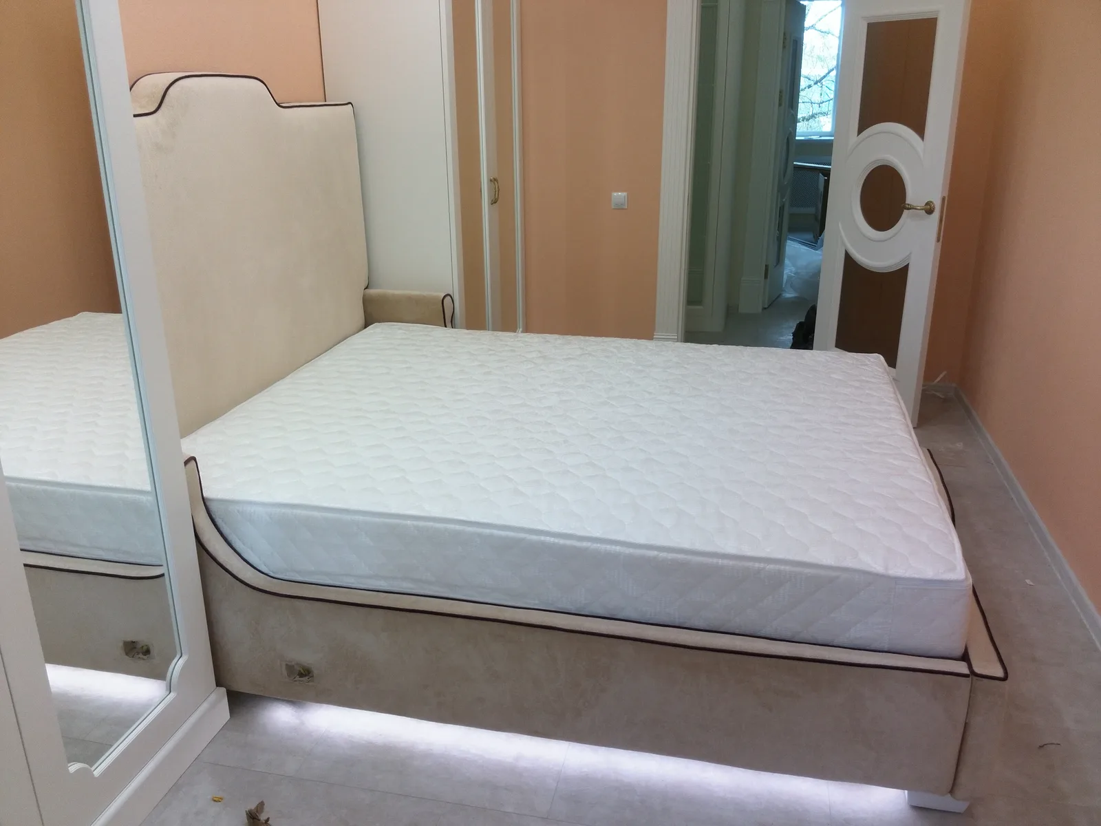 Un matelas nu sur son sommier, dans une chambre blanche